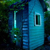 Abandoned glowing outhouse at blue hour